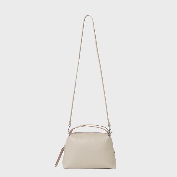 El bolso bandolera GIANNI CHIARINI ALIFA confeccionado en piel beige italiana presenta un diseño minimalista, correas ajustables, asas cortas y una parte superior con cremallera.